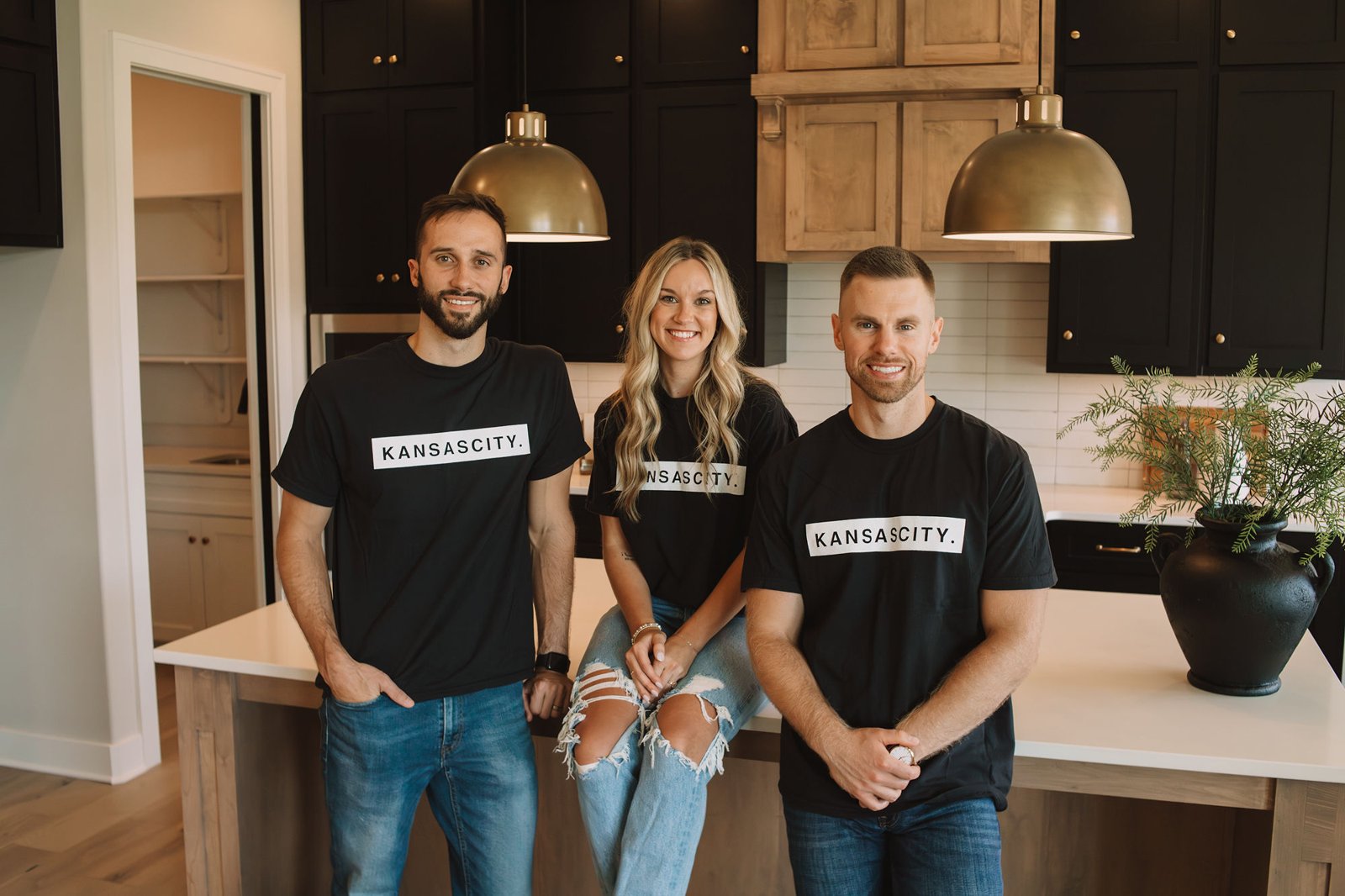 The Garver Group — Cam Walker, Kimberlin Tilton and Tanner Garver — wearing Kansas City shirts in a kitchen